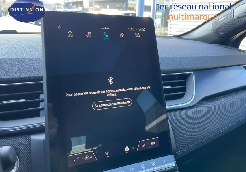 Écran tactile central allumé dans l’habitacle du Renault Captur bleu iron metal avec toit noir, vue côté droit.
