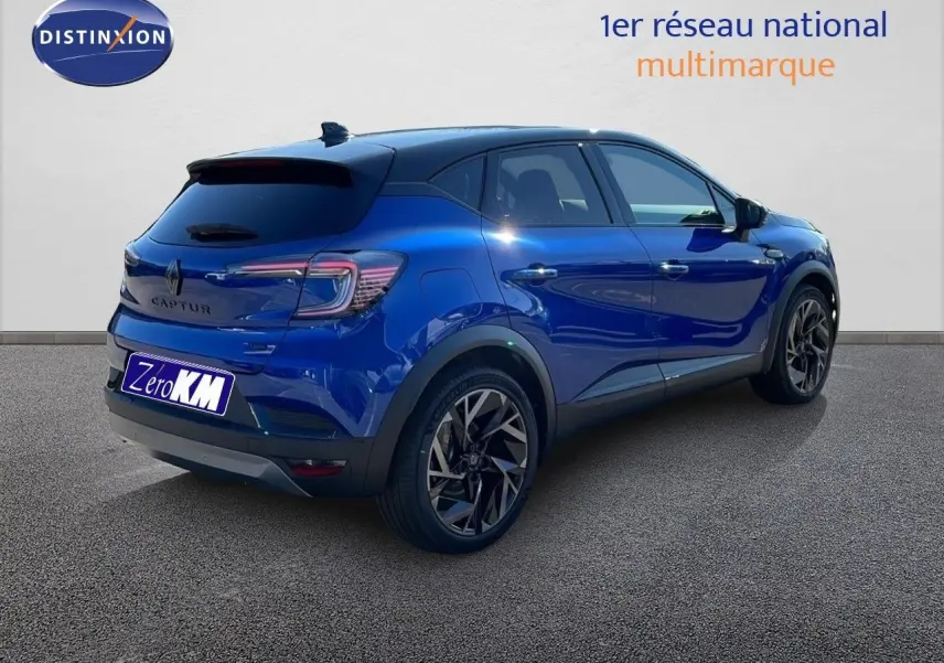Vue 3/4 arrière droite du Renault Captur E-Tech hybride bleu Iron Metal avec toit noir et jantes noires.