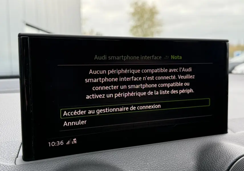 Écran central affichant l'interface Audi smartphone dans l'habitacle du Q2 noir Mythe, vue de face rapprochée.