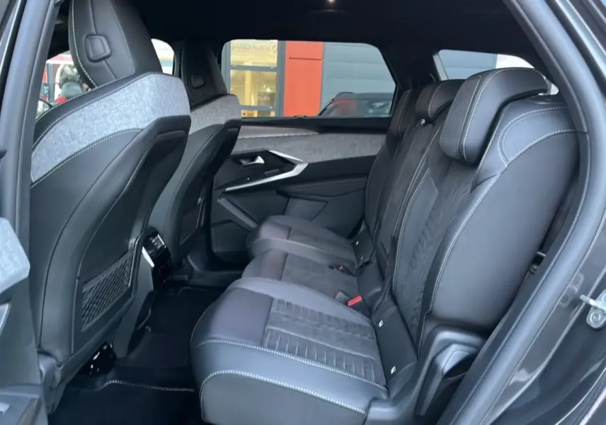 Vue latérale droite de l’intérieur arrière du Peugeot 5008 Hybrid GT, sièges en cuir Alcantara noir avec surpiqûres blanches.