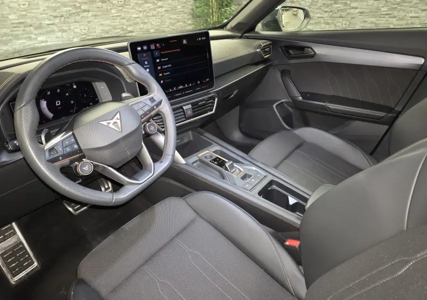 Vue intérieure côté conducteur du CUPRA Formentor noir, avec volant multifonction, écran tactile central et sellerie sport noire.