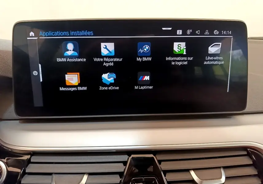 Écran tactile central affichant les applications BMW dans l'habitacle d'une BMW Série 5 Touring gris clair.