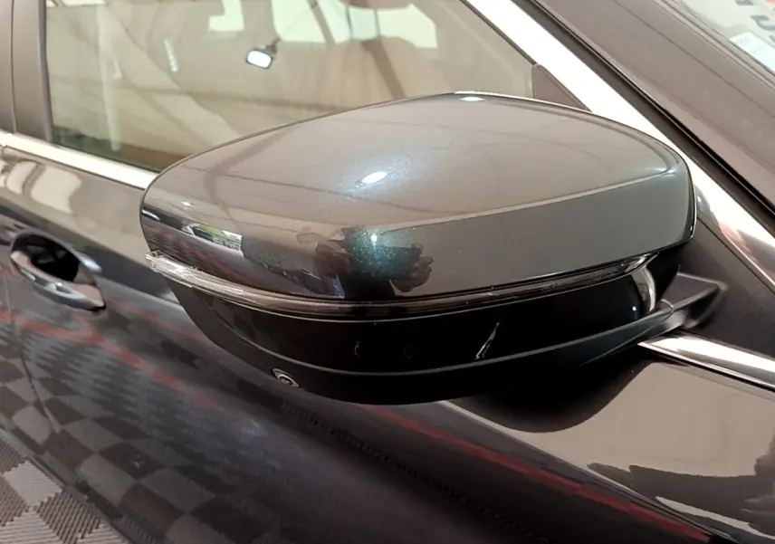 Rétroviseur côté gauche gris clair métallisé d'une BMW Série 5 Touring 530e avec clignotant intégré.