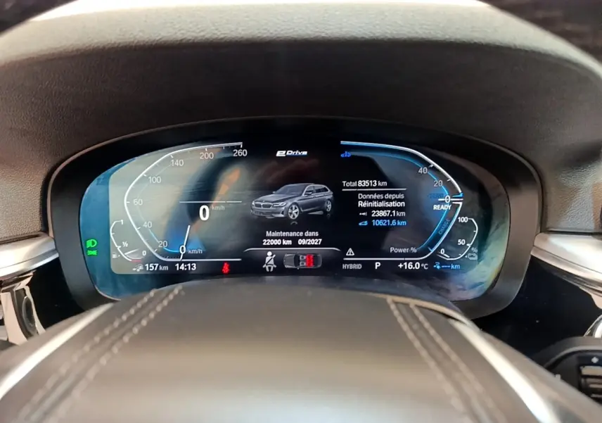Vue rapprochée du tableau de bord numérique de la BMW Série 5 Touring 530e hybride, affichant les données de conduite.