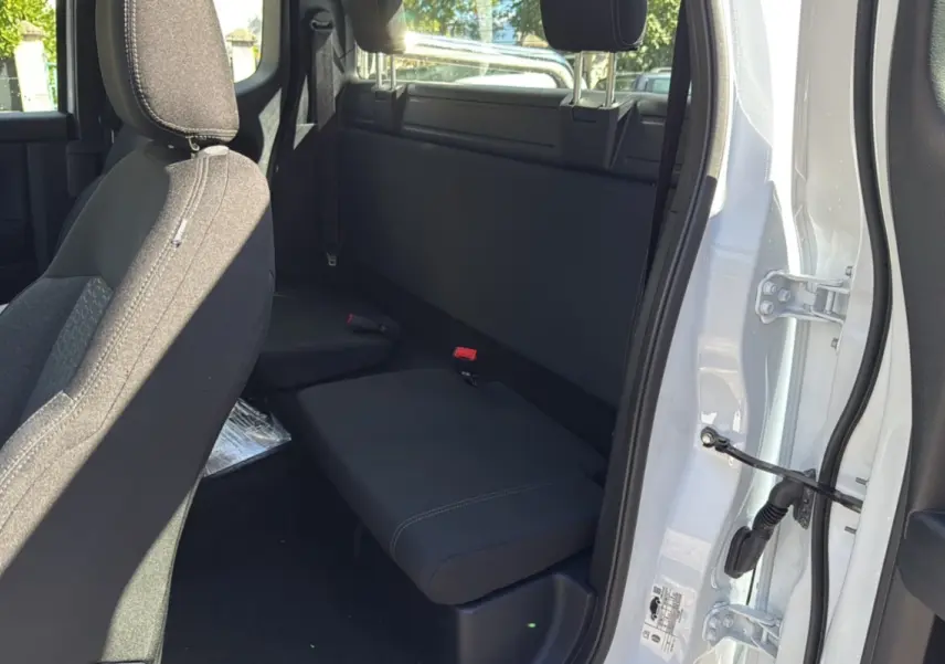 Vue intérieure côté arrière droit du Ford Ranger blanc glacier, montrant la banquette arrière et l'ouverture de la porte supercab.