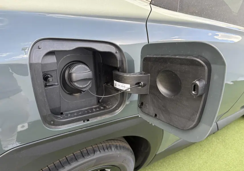 Gros plan sur la trappe à carburant côté gauche d’un Citroën C5 Aircross vert Astoria avec toit noir.