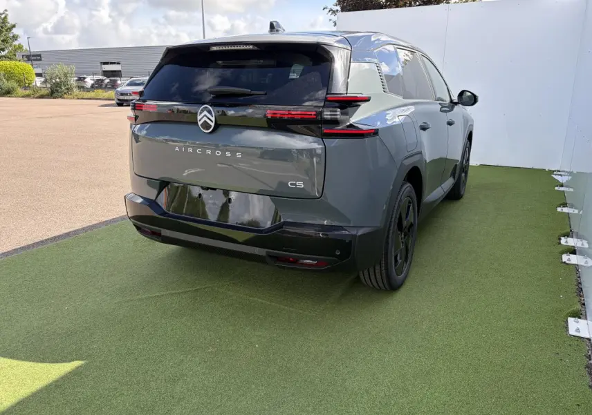 Vue 3/4 arrière droite d'un Citroën C5 Aircross vert Astoria avec toit noir et feux arrière LED distinctifs.