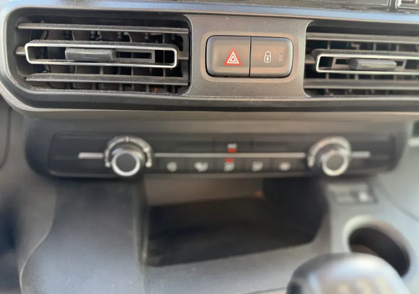 Gros plan sur la console centrale du Peugeot Rifter 2019, montrant les aérateurs et commandes de climatisation.
