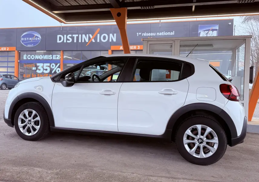 Profil droit d'une Citroën C3 Société blanche 2019 avec jantes alliage et protections noires sur les passages de roues.