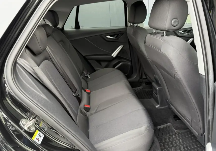 Vue intérieure côté droit des sièges arrière en tissu gris du SUV Audi Q2 noir Mythe 2023.