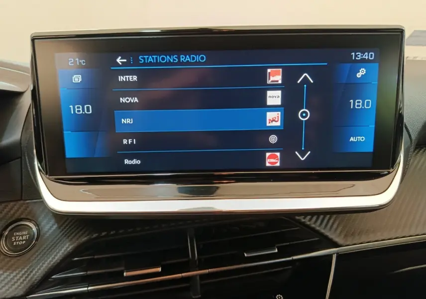 Écran tactile central affichant les stations radio dans l’habitacle noir d’une Peugeot 208 2020, version BlueHDi Allure Business.