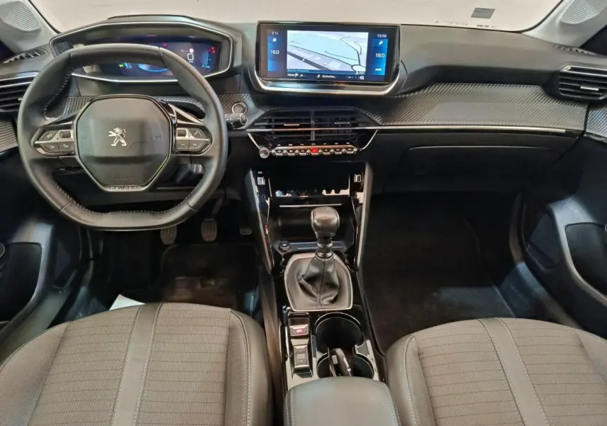 Vue intérieure avant de la Peugeot 208 BlueHDi 100 avec tableau de bord noir et écran tactile central 10 pouces.