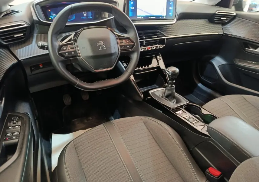 Vue intérieure avant droite de la Peugeot 208 2020, volant cuir multifonctions et écran tactile 10 pouces.