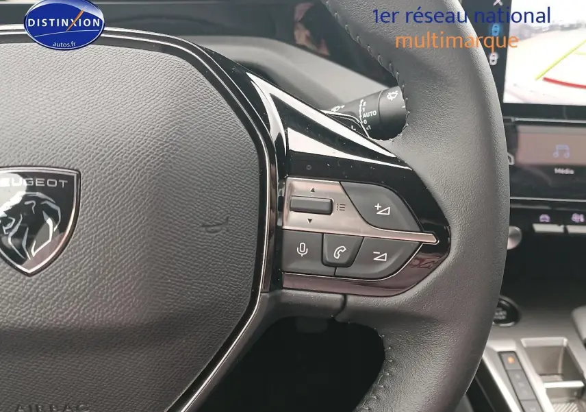 Gros plan sur le volant cuir multifonction de la Peugeot 408 Hybrid 145 allure 2024 avec commandes vocales et audio intégrées.