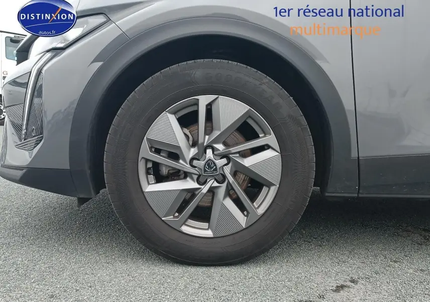 Gros plan sur la roue avant gauche et la jante alu gris sellenium d'une Peugeot 408 Hybrid 145 allure e-dcs6 2024.