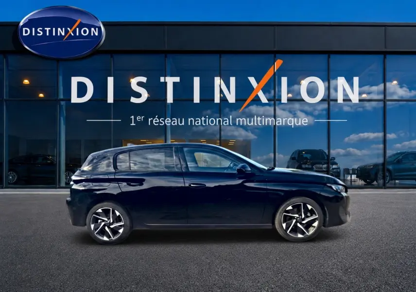 Profil droit d'une Peugeot 308 noire 2025 garée devant une vitrine avec logo Distinxion.