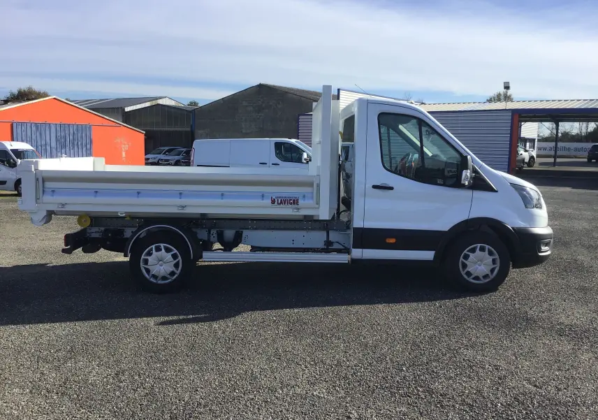Vue latérale droite d'un Ford Transit Chassis Cabine blanc avec benne basculante et bras polybenne, stationné en extérieur.