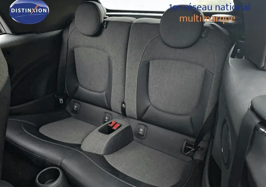 Vue intérieure arrière montrant les sièges arrière gris et noirs d'une MINI Cabriolet F57 rouge chili 2023.