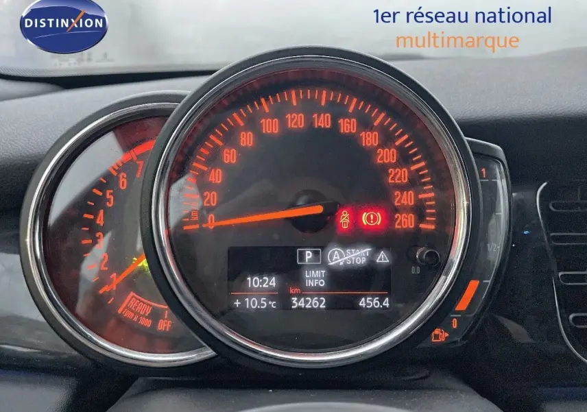 Gros plan sur le tableau de bord du MINI Cabriolet F57 rouge chili, affichant le compteur de vitesse et les voyants allumés.