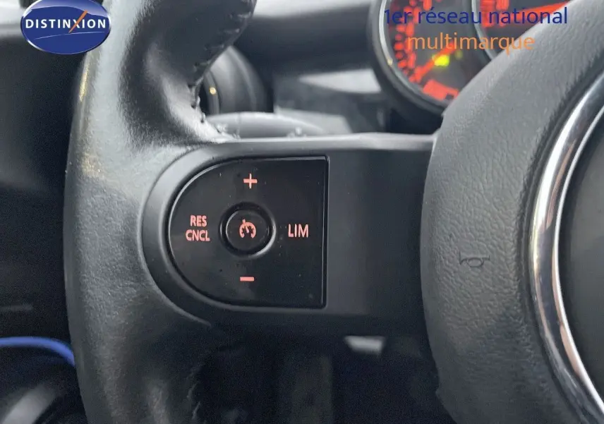 Gros plan sur les commandes de régulateur de vitesse au volant d'une MINI Cabriolet F57 rouge chili de 2023.