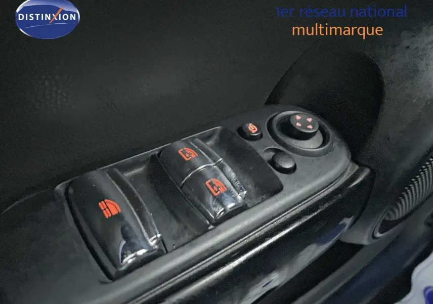 Gros plan sur les commandes de lève-vitres et réglage des rétroviseurs côté conducteur d'une MINI Cabriolet rouge chili 2023.