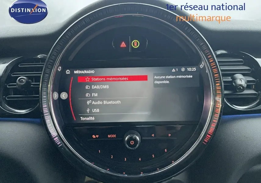 Écran central circulaire du tableau de bord de la MINI Cabriolet rouge chili 2023 affichant le menu média et radio.