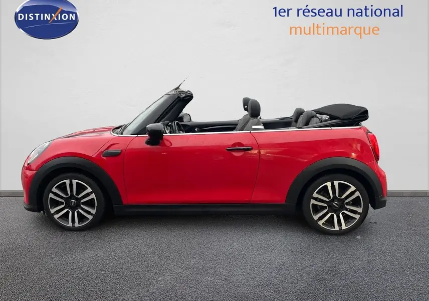Profil droit d'une MINI Cabriolet F57 rouge chili 2023 avec capote noire repliée et jantes alliage bicolores.