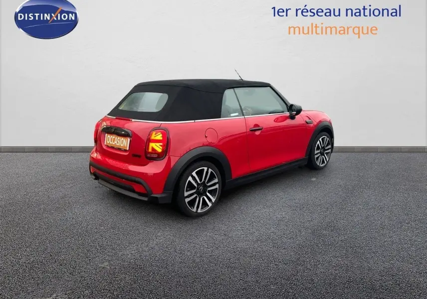MINI Cabriolet F57 rouge chili vue 3/4 arrière côté droit avec toit souple noir et feux arrière à motif Union Jack.