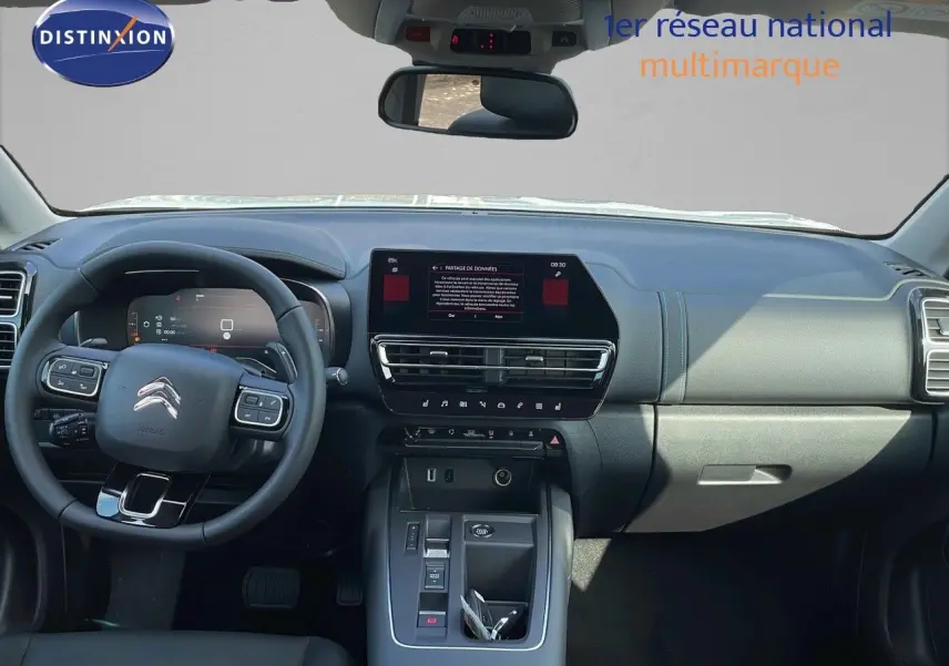 Vue intérieure avant du Citroën C5 Aircross 2025 avec tableau de bord moderne et volant multifonction noir.