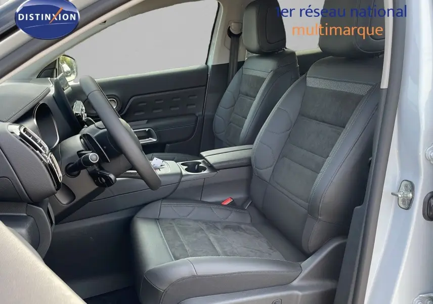 Intérieur avant droit du Citroën C5 Aircross blanc Okenite, sièges cuir noir et alcantara, volant multifonction visible.
