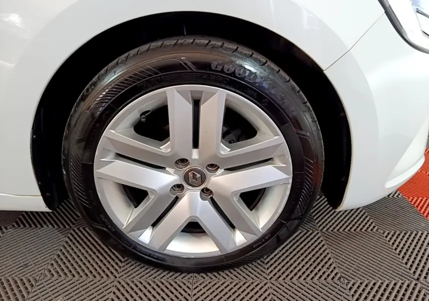 Gros plan sur la roue avant droite d'une Renault Clio blanche avec jante alliage et pneu Goodyear.