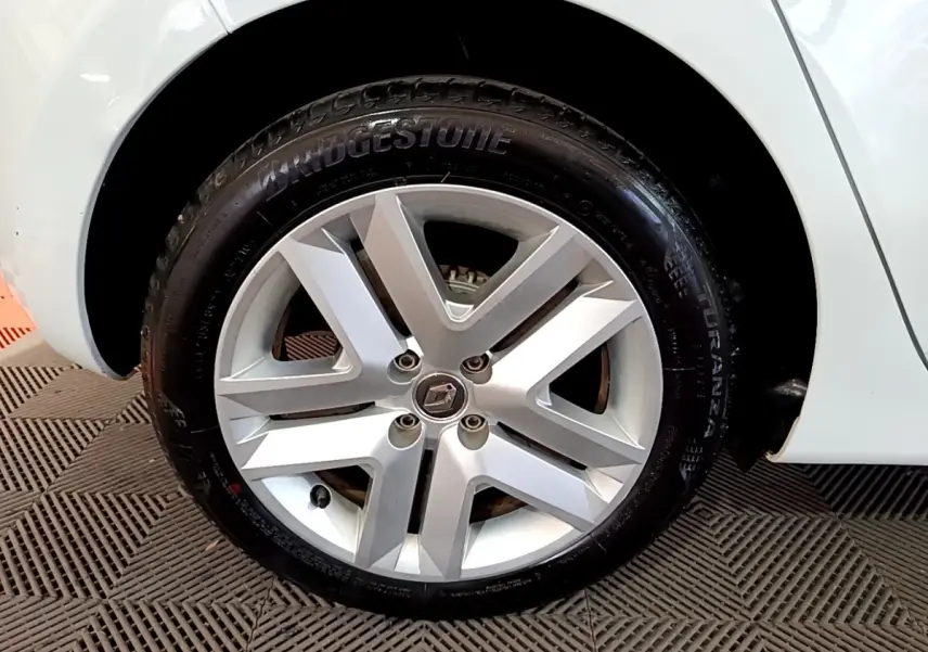 Gros plan sur la roue avant droite blanche d’une Renault Clio Business 2021 avec jante alliage et pneu Bridgestone.