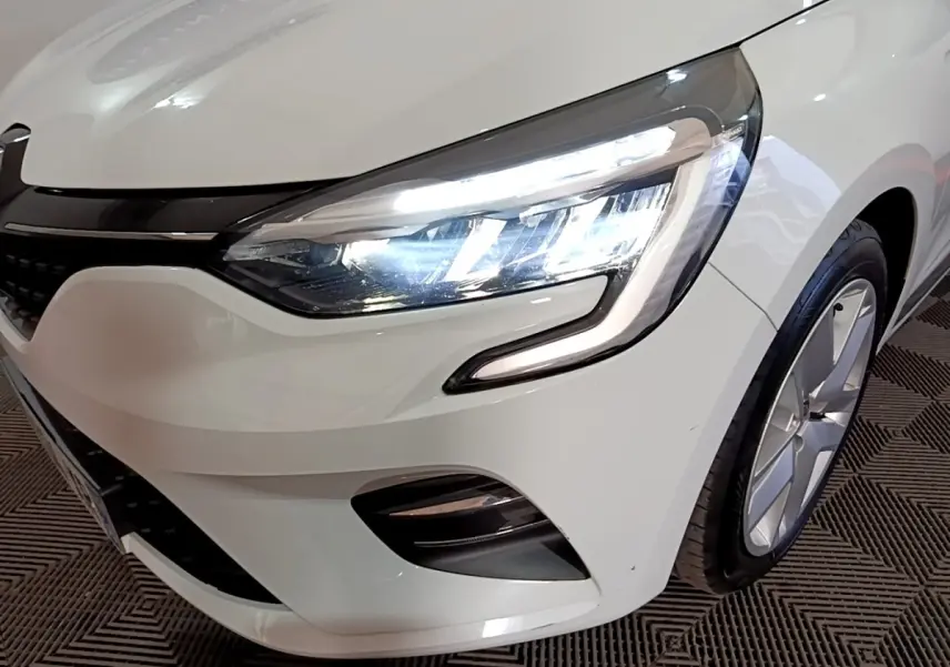 Gros plan sur l'avant droit blanc de la Renault Clio Business avec phare LED allumé et jante visible.