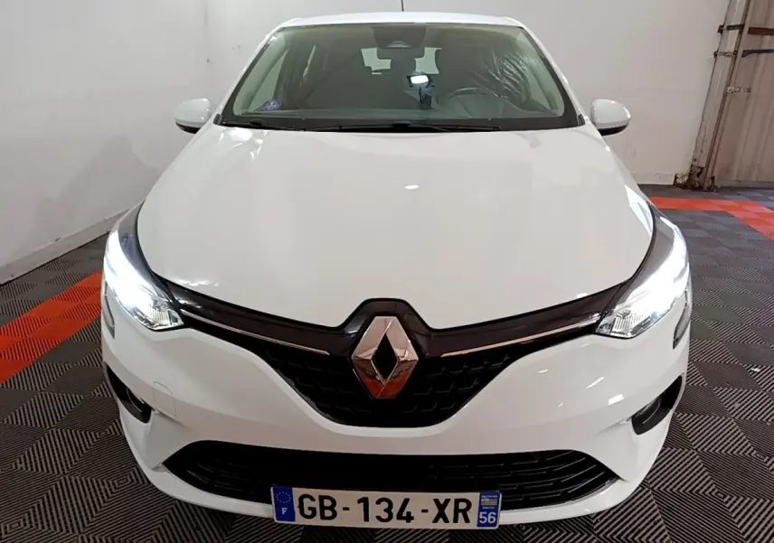 Vue avant d'une Renault Clio Business blanche avec phares LED allumés dans un garage.
