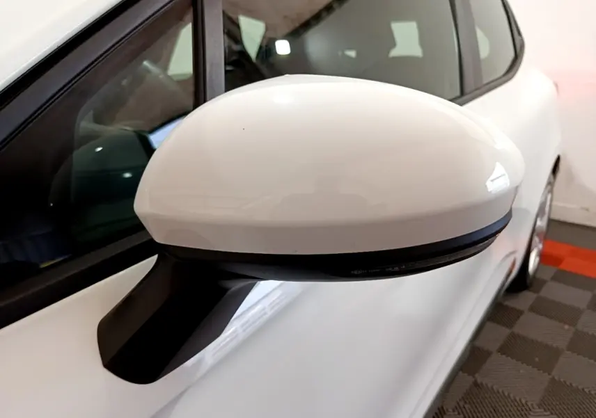 Rétroviseur blanc côté gauche en gros plan sur Renault Clio Business 2021, carrosserie blanche visible en arrière-plan.