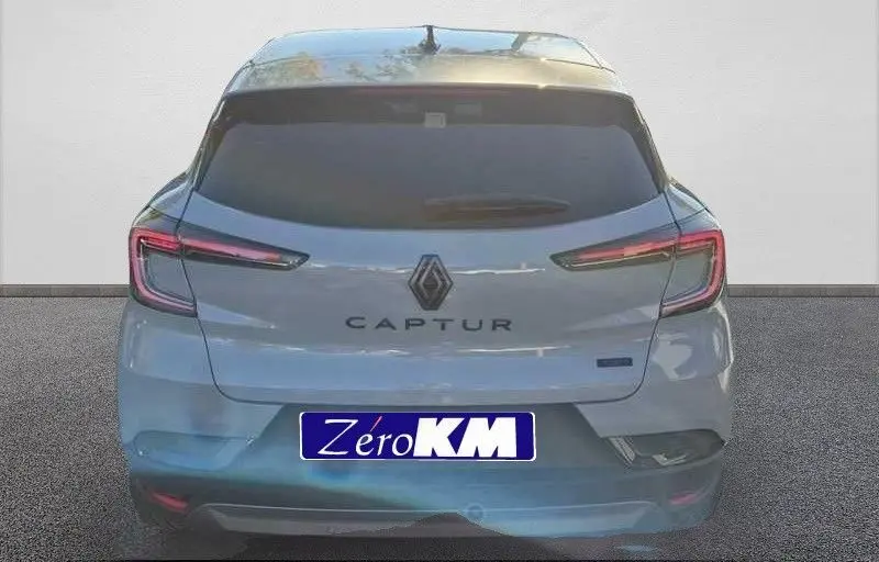 Vue arrière d'un Renault Captur E-Tech hybride gris Rafale avec toit gris, feux LED fins et logo central bien visible.