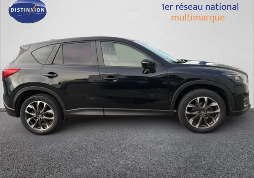 Profil côté gauche d'un Mazda CX-5 noir de 2017 avec jantes alliage 19 pouces et attelage fixe visible.