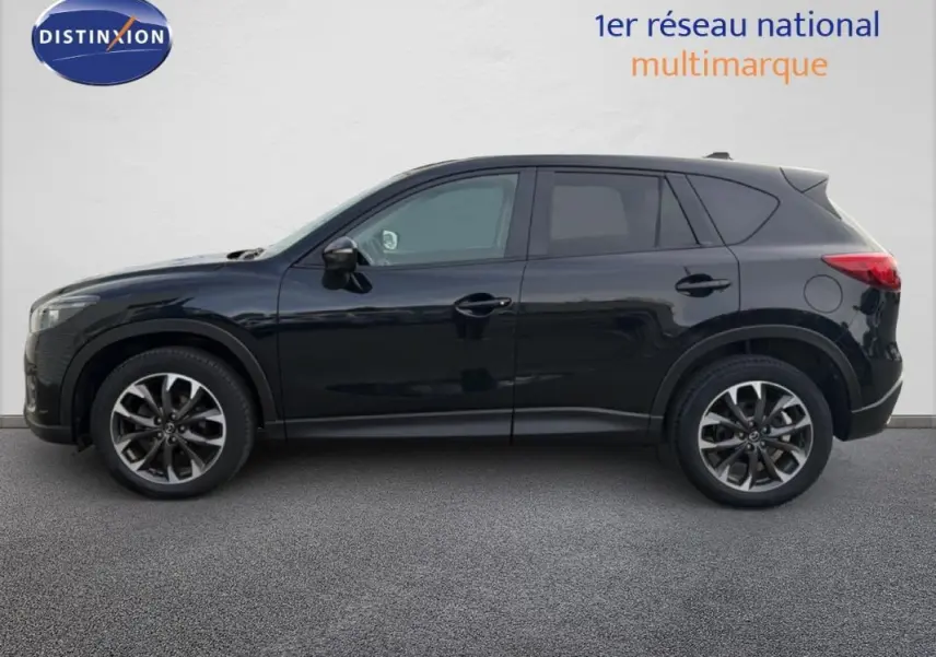 Vue latérale droite d'un Mazda CX-5 noir de 2017 avec jantes alliage et rétroviseurs électriques rabattables.
