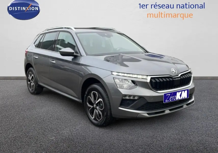 Vue 3/4 avant d'un Skoda Kamiq gris graphite métal 2025 avec calandre noire et jantes bi-ton.