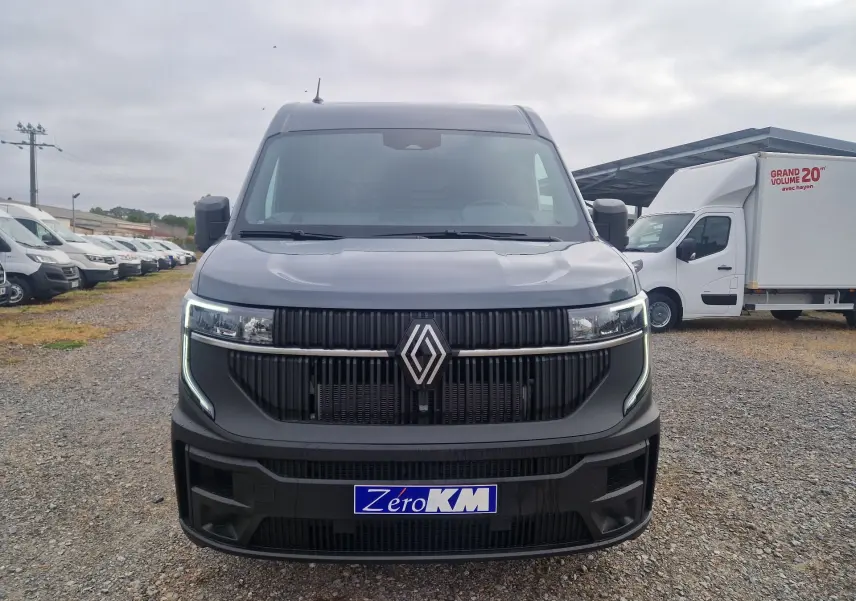 Vue avant d’un Renault Master gris urbain 2026 avec calandre noire et feux LED en forme de C allumés.