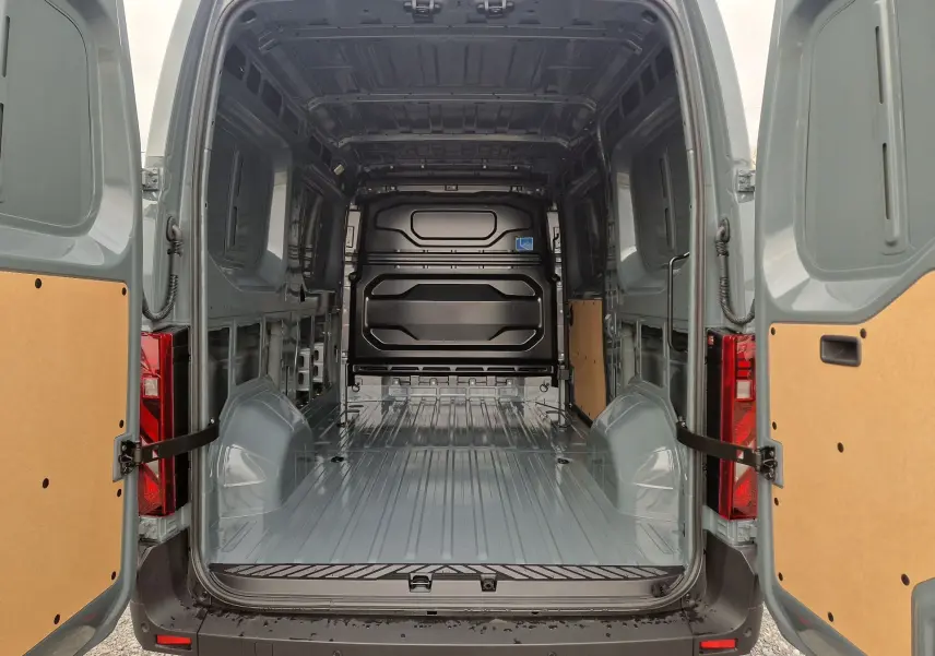 Vue arrière ouverte du Renault Master L2H2 2026 gris urbain montrant l’espace de chargement vide et les portes arrière ouvertes.