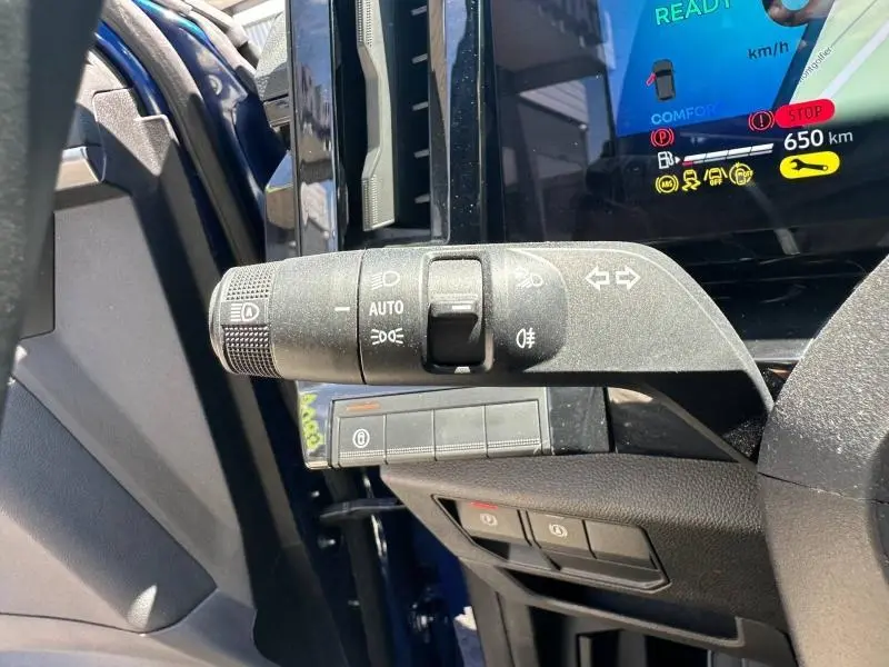 Gros plan sur la commande des feux et clignotants à gauche du volant dans un Renault Austral Bleu Iron 2025.