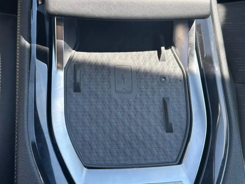 Vue rapprochée du chargeur sans fil noir intégré à la console centrale du Renault Austral 2025.
