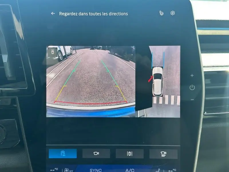 Écran tactile intérieur montrant la caméra de recul et vue 360° du Renault Austral bleu Iron avec toit noir étoilé.
