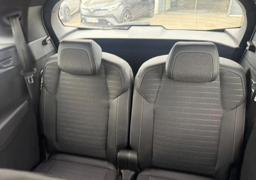 Vue arrière intérieure des deux sièges noirs du Peugeot 5008 Hybrid 145 ch e-DCS6 GT avec appuie-têtes intégrés.
