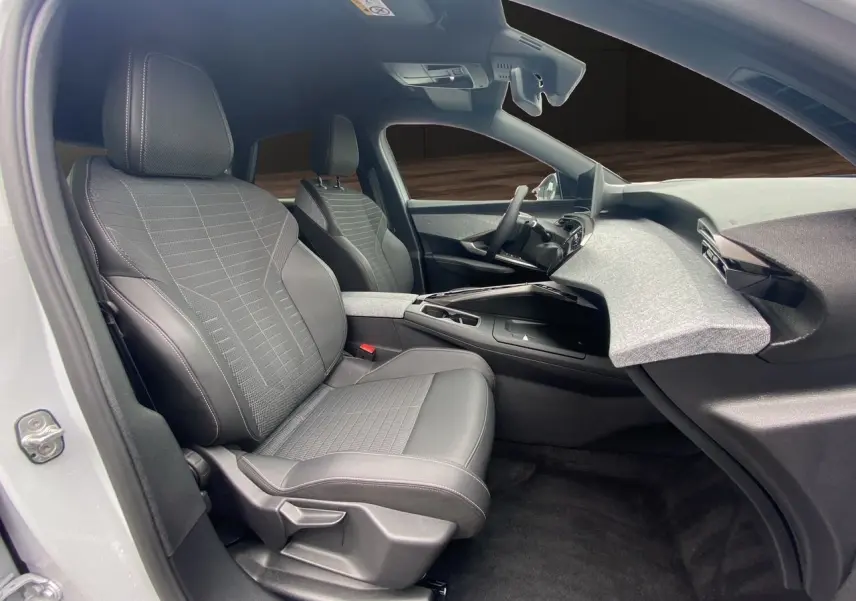 Vue intérieure côté gauche du Peugeot 3008 blanc Okenite 2024, sièges tissu et cuir gris avec tableau de bord moderne.