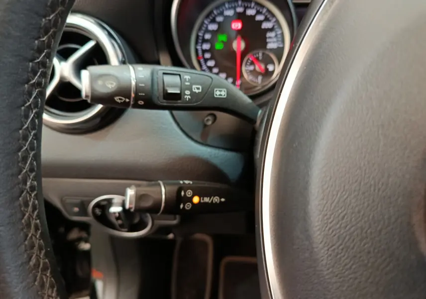 Gros plan sur le volant cuir et commandes au volant du tableau de bord noir du Mercedes GLA 220 d 2018.
