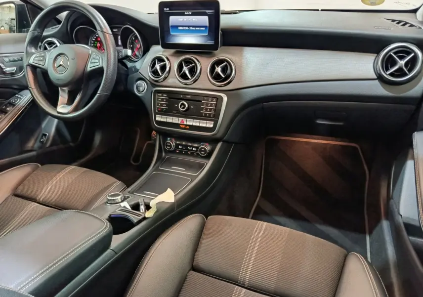 Intérieur noir du Mercedes GLA 220 d 2018 vu côté conducteur, avec tableau de bord et écran central tactile.