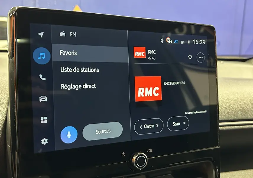 Écran tactile central de la Toyota Yaris Cross 2025 affichant la radio RMC en mode FM, intérieur beige.