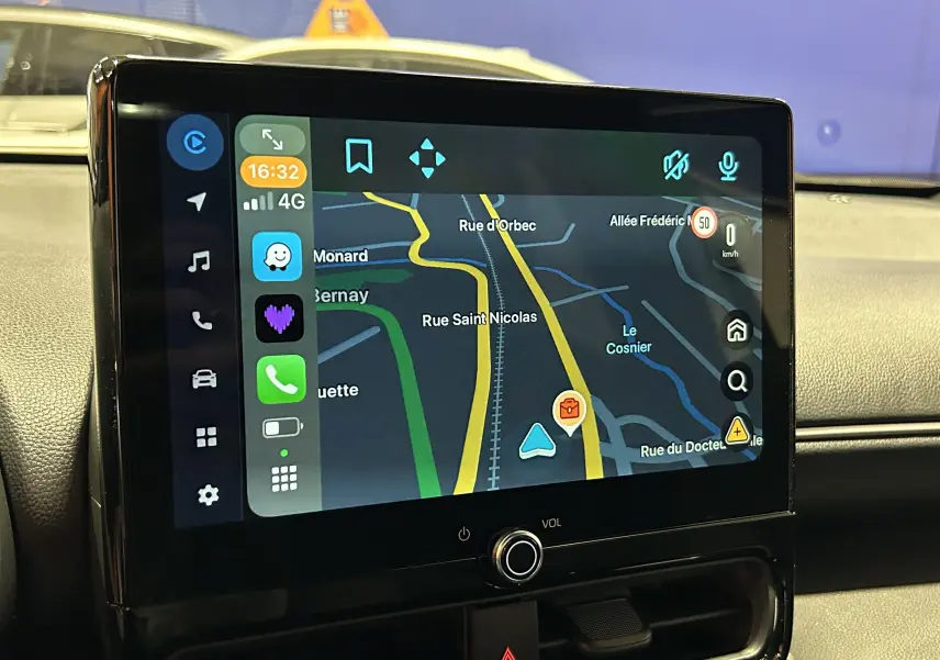 Écran tactile central affichant la navigation GPS dans l'habitacle de la Toyota Yaris Cross blanche 2025.